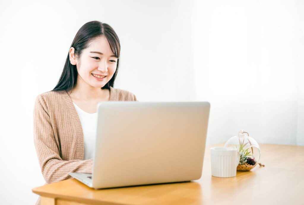 パソコンの前で笑顔の女性