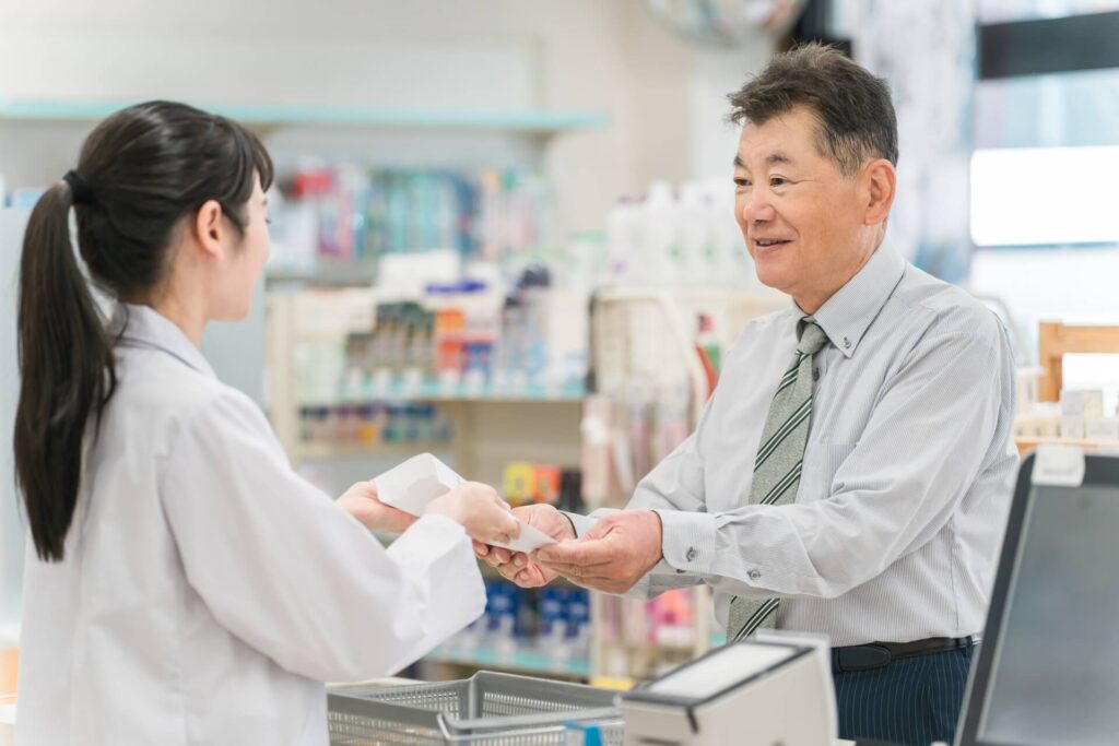 薬を手渡す薬剤師女性